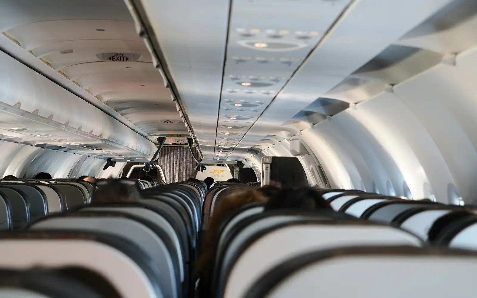 Rows of seats and overhead bins inside a passenger aircraft cabin.